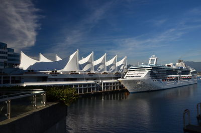 Boats moored at harbor against sky