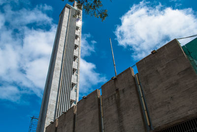 Low angle view of buildings against cloudy sky