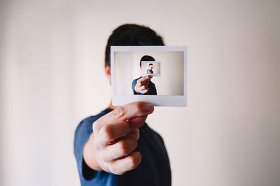 Person holding a photograph of himself