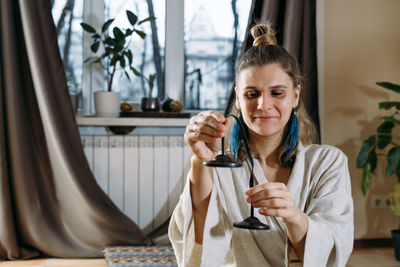 Young woman using mobile phone while sitting at home