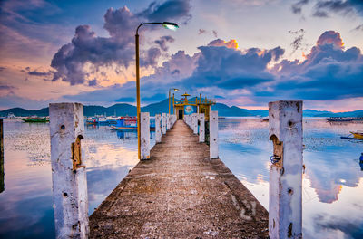 Pier over sea against sky during sunset