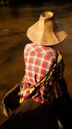 Rear view of mahout on elephant in lake