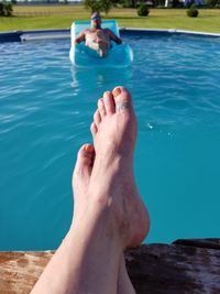 Low section of man relaxing in swimming pool