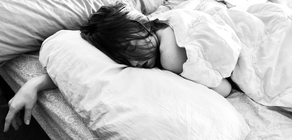 High angle view of woman sleeping on bed at home