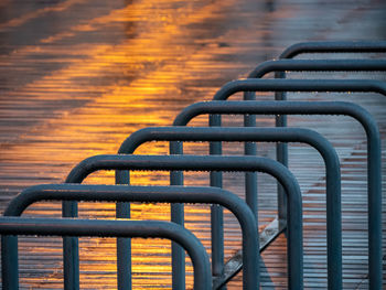 Wet bicycle rack in city during sunset