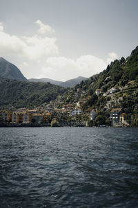 Scenic view of sea by townscape against sky