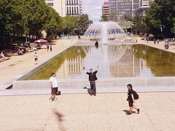 People on fountain in city