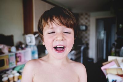 Close-up of cute shirtless boy smiling at home