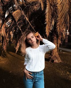 Young woman standing on palm tree