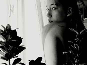 Full length of shirtless young woman standing at home