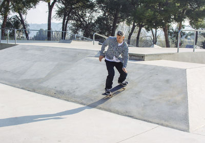 Man skateboarding on ramp in park