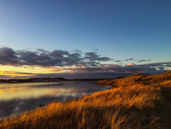 Scenic view of lake against sky during sunset