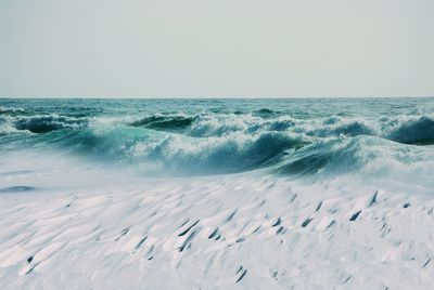 Scenic view of sea against clear sky and snow