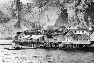 Houses by sea against mountains