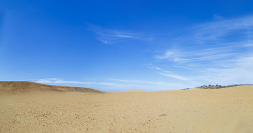 Scenic view of desert against blue sky