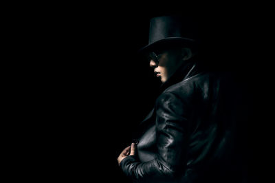 Man wearing hat against black background