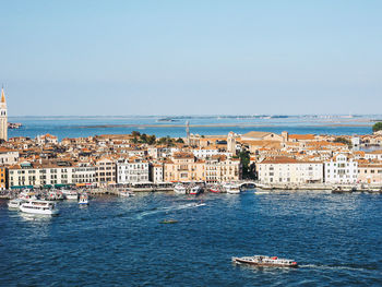 Scenic view of sea and buildings against clear sky