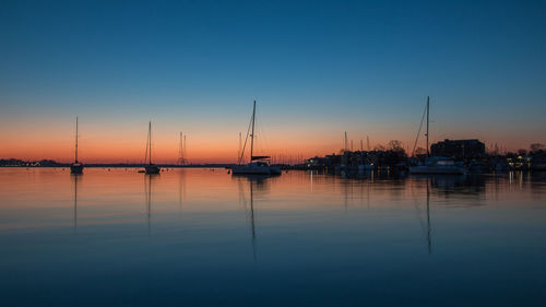 Sailboats in marina at sunset