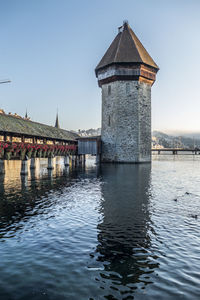 Luzern is reflected on the river on a sunny day with the chapel bridge