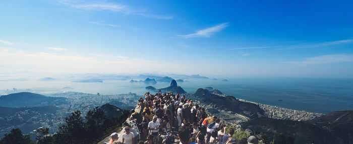 People on rock against sky