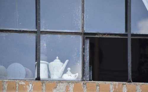 Kettles and utensils seen from broken window