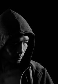 Close-up of young man against black background