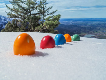 Close-up of multi colored snow on land against sky