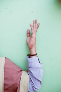 Midsection of woman with hands against wall
