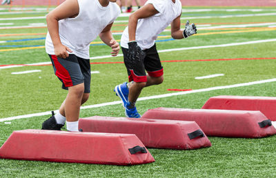 Low section of people playing soccer on field