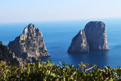 Scenic view of rock formation in sea against clear sky