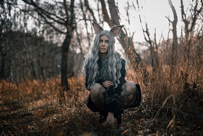 Young woman standing against tree during autumn