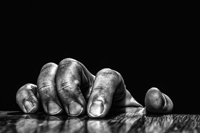 Close-up of human hand against black background