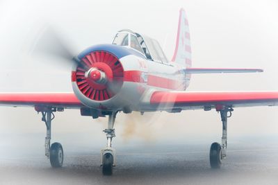 Close-up of airplane flying in airport runway