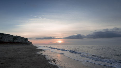 Scenic view of beach against sky during sunset