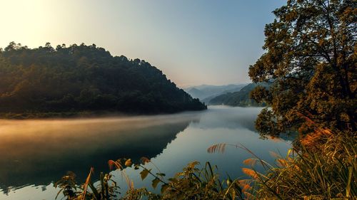 Scenic view of lake against sky at sunset