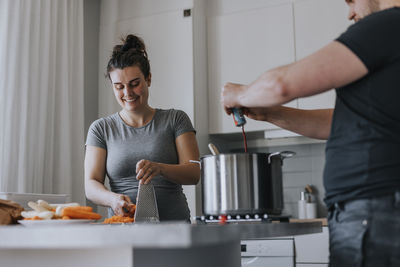 Couple in kitchen preparing food together