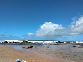 Scenic view of beach against blue sky