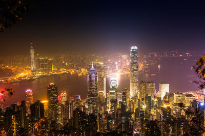 Illuminated buildings in city against sky at night