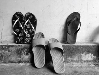 Close-up of footwear against wall