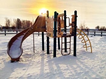 Scenic view of snow covered field against sky during sunset