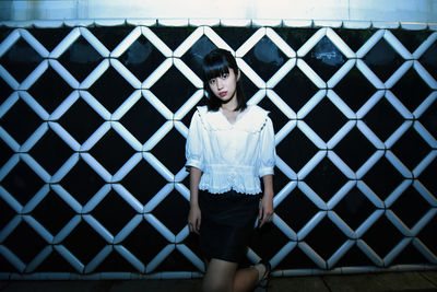 Full length of woman standing against wall