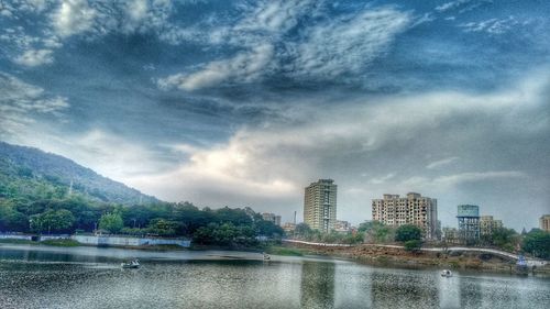Scenic view of calm river against cloudy sky