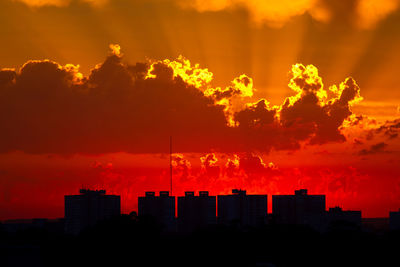 Silhouette cityscape against sky during sunset