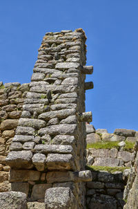 Low angle view of old ruin against clear blue sky