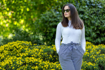 Portrait of woman standing against plants