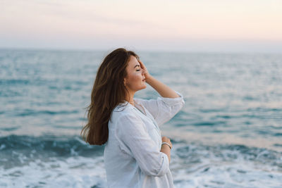 Portrait of a happy young woman on a background of beautiful sea.