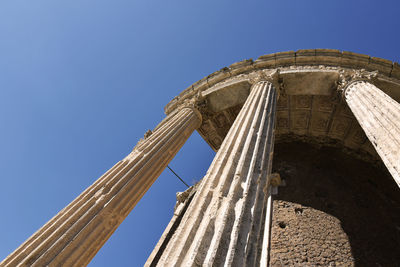 Low angle view of damaged building against clear blue sky