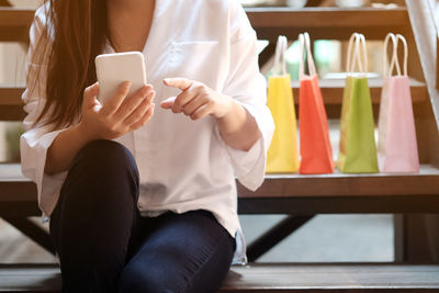 Midsection of woman using mobile phone