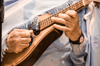 Midsection of man playing guitar