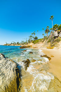 Scenic view of beach against clear blue sky